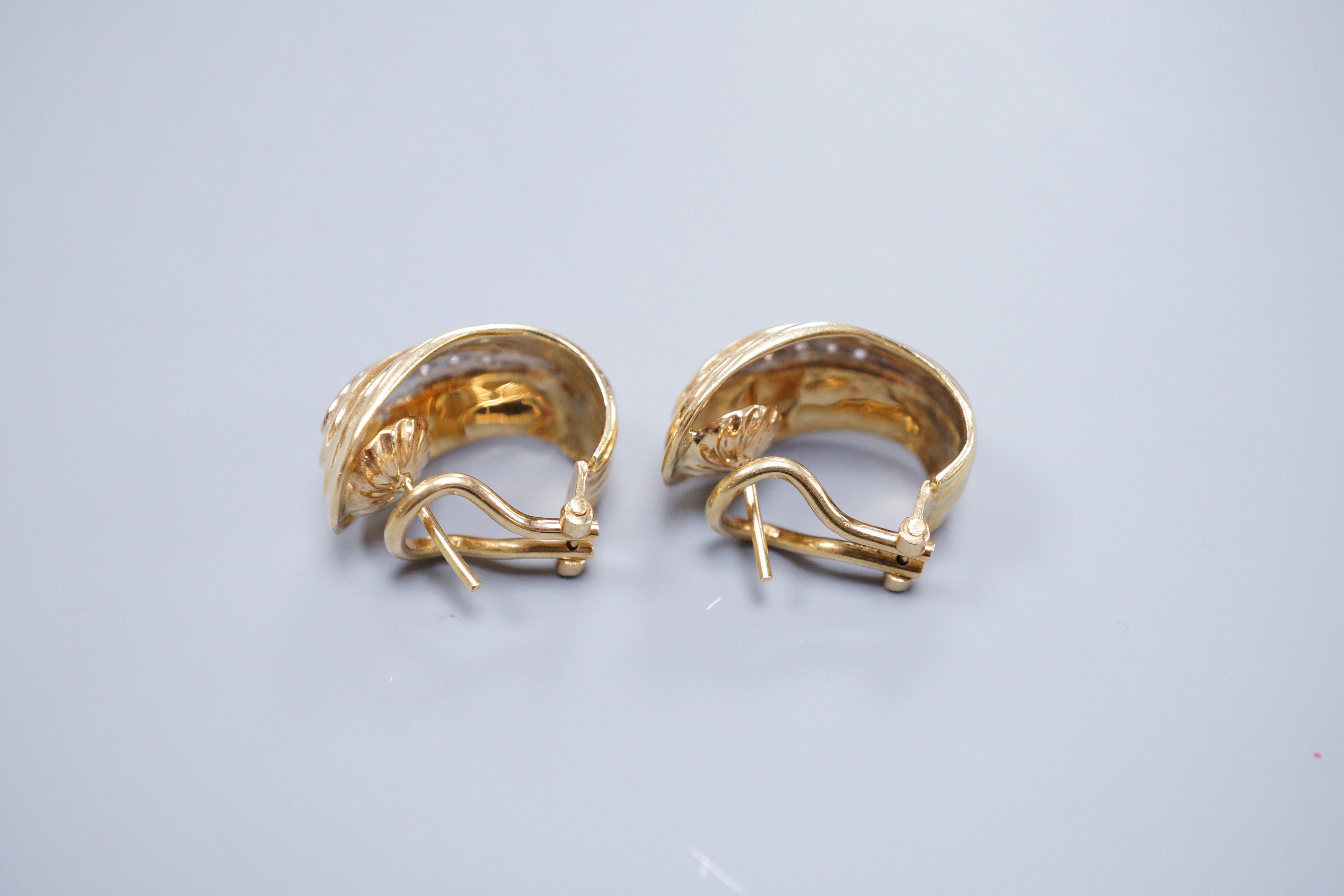 A pair of 18k yellow metal and diamond chip scroll shaped ear-clips, 2cm, gross 13 grams